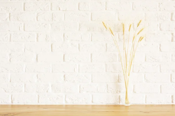 Vue de face des pointes de blé sur la surface en bois et le fond en brique blanche. Maquette — Photo