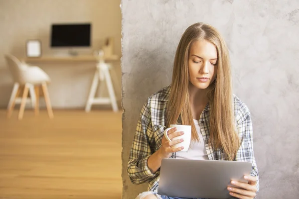 Kvinna dricker kaffe, med laptop — Stockfoto