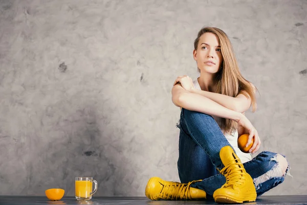 Задумчивая девушка с апельсинами — стоковое фото