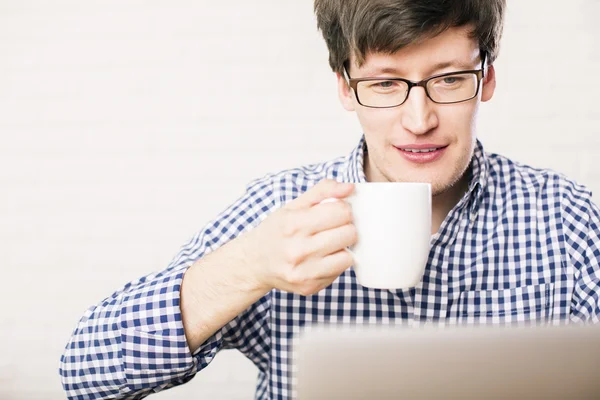 男はコーヒーを飲むとラップトップを使用して — ストック写真