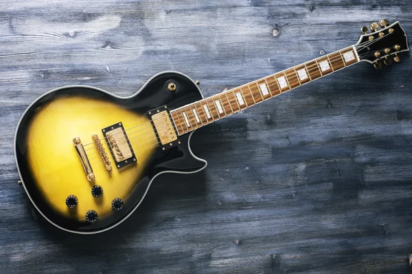 Elektrische gitaar op houten oppervlak — Stockfoto