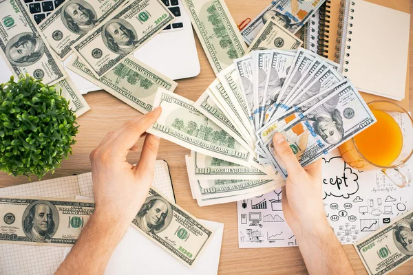 Человек играет с долларовыми банкнотами — стоковое фото