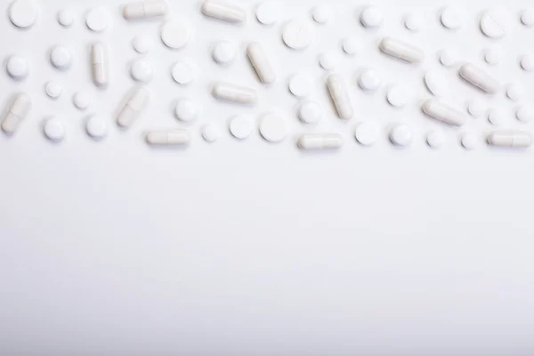 Białe tabletki na jasnym tle — Zdjęcie stockowe