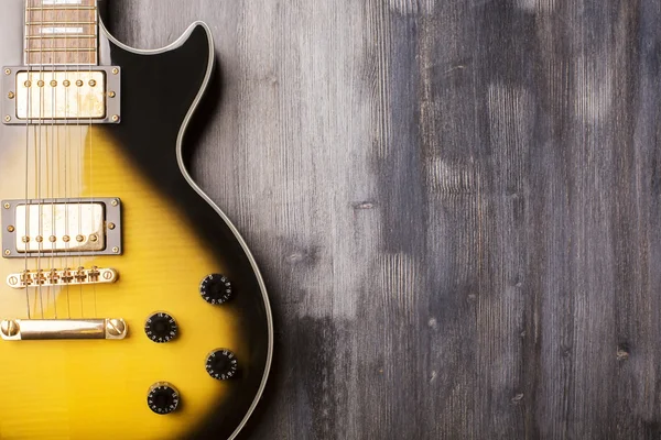 Guitarra vertical sobre superficie de madera — Foto de Stock