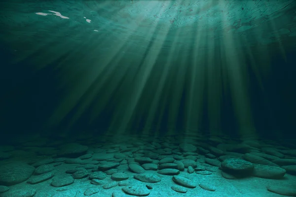 Pedras e raios solares debaixo de água — Fotografia de Stock