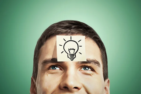 Lightbulb sketch on forehead — Stock Photo, Image