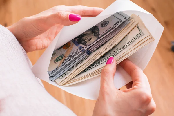 Female holding envelope with cash — Stock Photo, Image