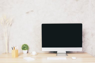 Boş bilgisayar monitörü, klavye, kahve fincanı, bitki ve diğer kırtasiye ve dekoratif öğeleri ile Yaratıcı tasarımcı masaüstü. Alay etmek