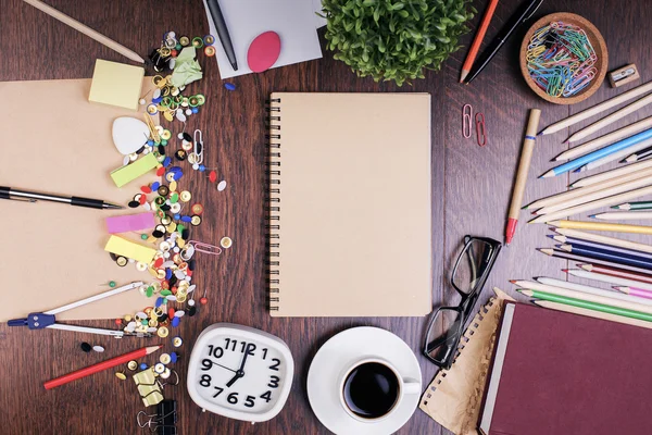 Escritorio desordenado con bloc de notas en blanco — Foto de Stock