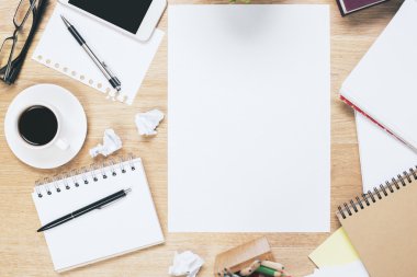 Messy workplace with blank papersheet