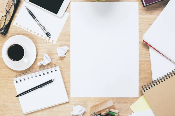 Lugar de trabajo desordenado con hoja de papel en blanco — Foto de Stock