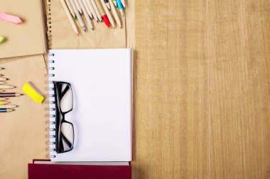 Gözlük, not defteri ve kalemler