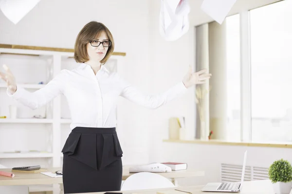 Розлючена жінка кидає папери в офіс — стокове фото