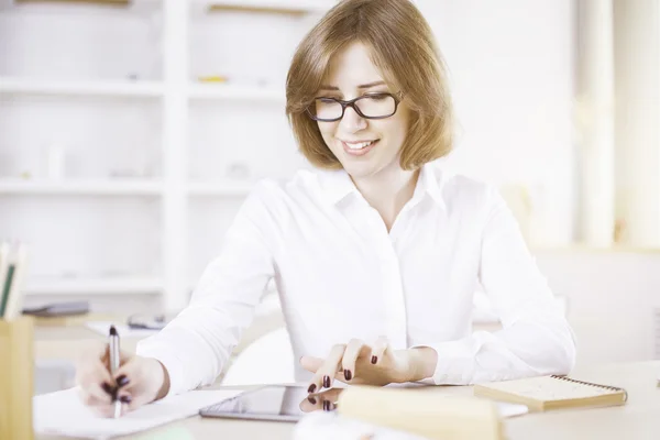 Mujer con tableta haciendo papeleo — Foto de Stock