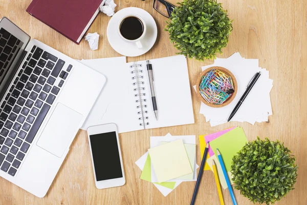 Messy desk with technology and supplies — Stock Photo, Image