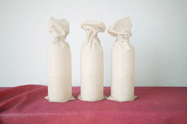 Tre flaskor förpackade i papper — Stockfoto