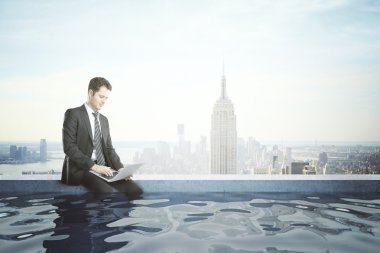 Businessman with notebook in rooftop pool clipart