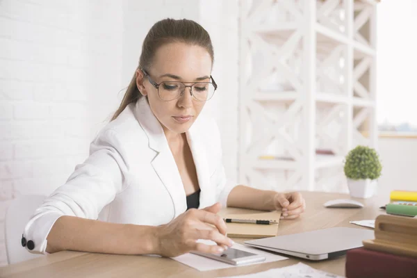 Donna che utilizza il cellulare a tavola — Foto Stock