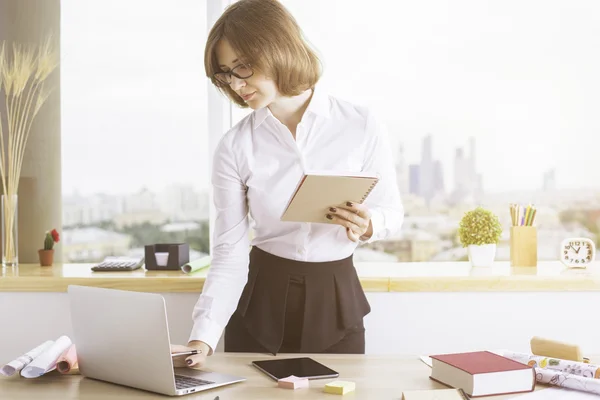 Geschäftsfrau mit Notizblock und Laptop — Stockfoto