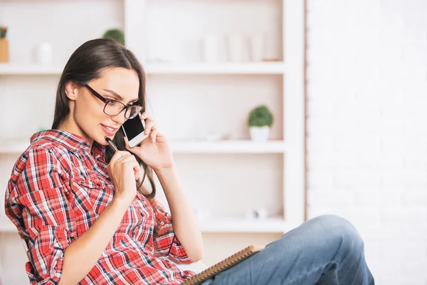 Krásná dívka na telefonu a bere si poznámky — Stock fotografie