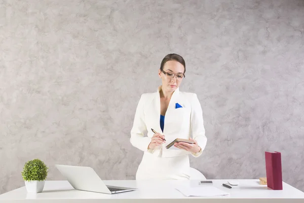 Frau schreibt in Notizblock — Stockfoto