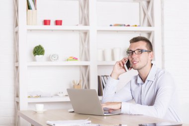 İş adamı telefonda dizüstü bilgisayar kullanıyor