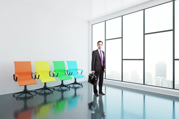 Biznesmen i kolorowe krzesła obrotowe — Zdjęcie stockowe
