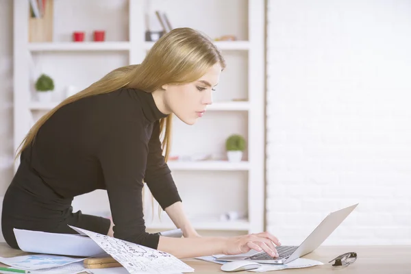 Woman on tabletop using laptop — Stock Photo, Image