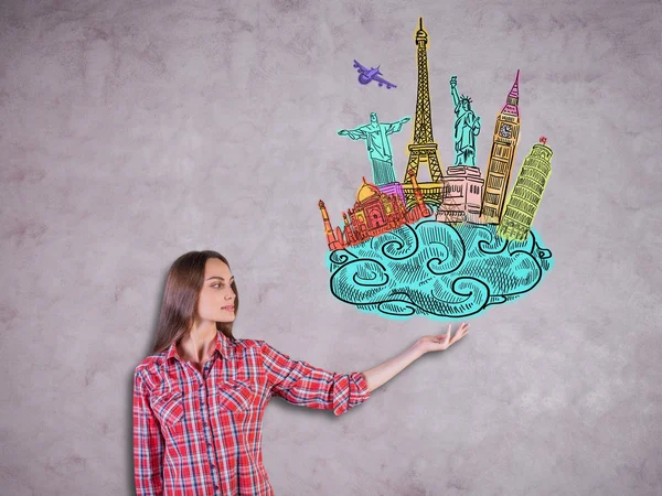 Travel concept with young lady in casual shirt holding abstract sketch of landmarks and sights on concrete background — Stock Photo, Image