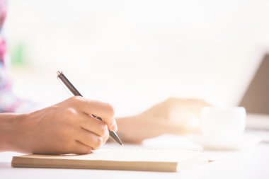 Woman's hand writing in notepad