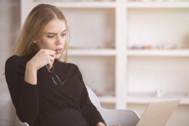 Dizüstü bilgisayar kullanan düşünceli kadın