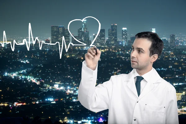 Doctor drawing cardiogram on city background — Stock Photo, Image