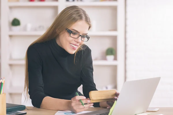 Kvinna med bärbar dator vid skrivbordet — Stockfoto