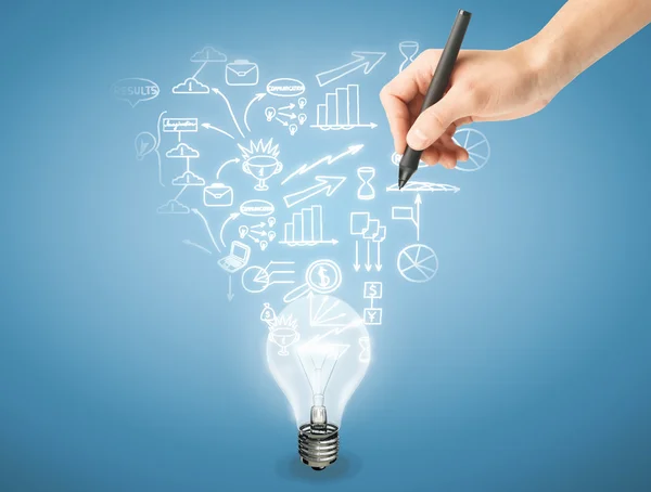 Die Hand eines Mannes zeichnet Geschäftsikonen über einer Glühbirne auf hellblauem Hintergrund. Geschäftsidee Konzept — Stockfoto