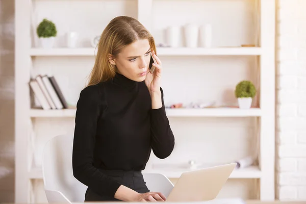 Woman on phone using notebook — 图库照片