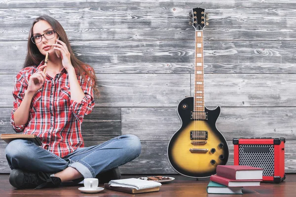 Young lady on floor with guitar — Stock fotografie