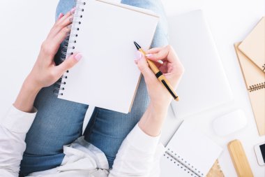 Woman writing in notepad topview