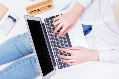 Woman in jeans using laptop