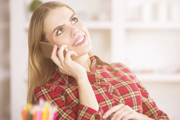 Ženská mluvící na telefonu a na pracovišti — Stock fotografie