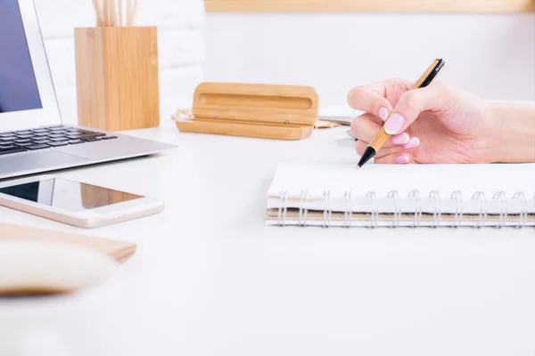 Female hand writing in notepad side Stock Image