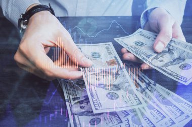 Finansal grafiğe çoklu pozlama hologram, Amerikan dolarları ve insan eli. Analiz kavramı.