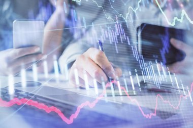 Kadın ve erkeğin birlikte çalışması ve finansal grafik hologramı. İş konsepti. Bilgisayar arkaplanı.