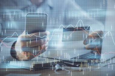 Ellerinde kredi kartı ve forex çizimi olan bir adamın çift pozu. İnternet E-ticaret kavramında hisse senedi ve dijital fintech.