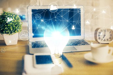 Bilgisayar ofisinde ampul simgesi hologramıyla birlikte. Çifte maruziyet. Fikir kavramı.