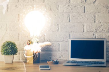 Bilgisayar ofisinde ampul simgesi hologramıyla birlikte. Çifte maruziyet. Fikir kavramı.