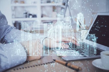 Arka planda bilgisayar üzerinde çalışan bir iş adamı ile yüksek teknoloji şehir çizimi. Akıllılık konsepti. Çift pozlama.