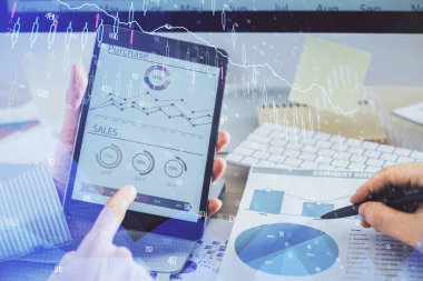 Bir adamın el ele tutuşması ve telefon ve finansal çizim kullanması. Pazar analizi kavramı.