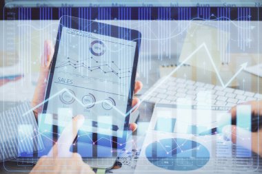 Bir adamın el ele tutuşup, telefon ve finansal çizim kullanırken birden fazla pozlama. Pazar analizi kavramı.