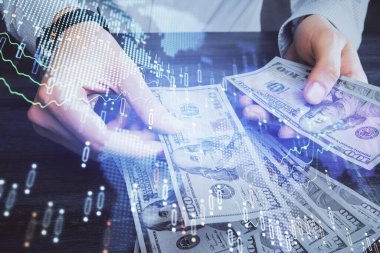 Finansal grafiğe çoklu pozlama hologram, Amerikan dolarları ve insan eli. Analiz kavramı.