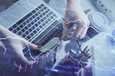 İşkadını ellerinin bilgisayar ve finansal grafik hologramı çizimlerinde çifte pozlama. Borsa analizi kavramı.